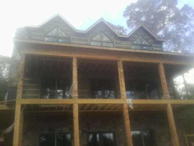 Dormers and porch framing on a large log home under construction — Roof Coating work by our crew in Flower Mound