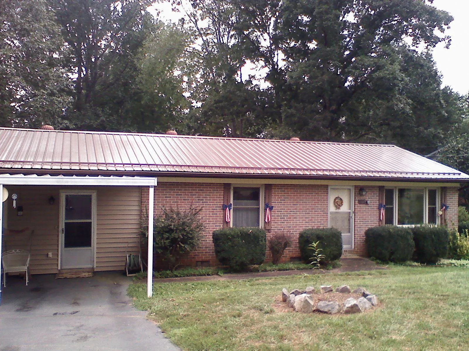Bronze metal roof and carport on a brick ranch home — Roof Repair work by our crew in Flower Mound