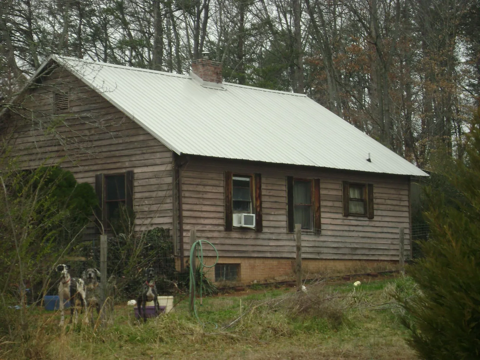 White metal roof on an old wood sided farmhouse, from a Metal Roof Installation job in Flower Mound